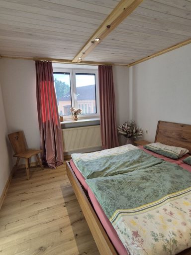 Zimmer mit Doppelbett im Bauernstil mit handgefertigten Naturholzmöbeln